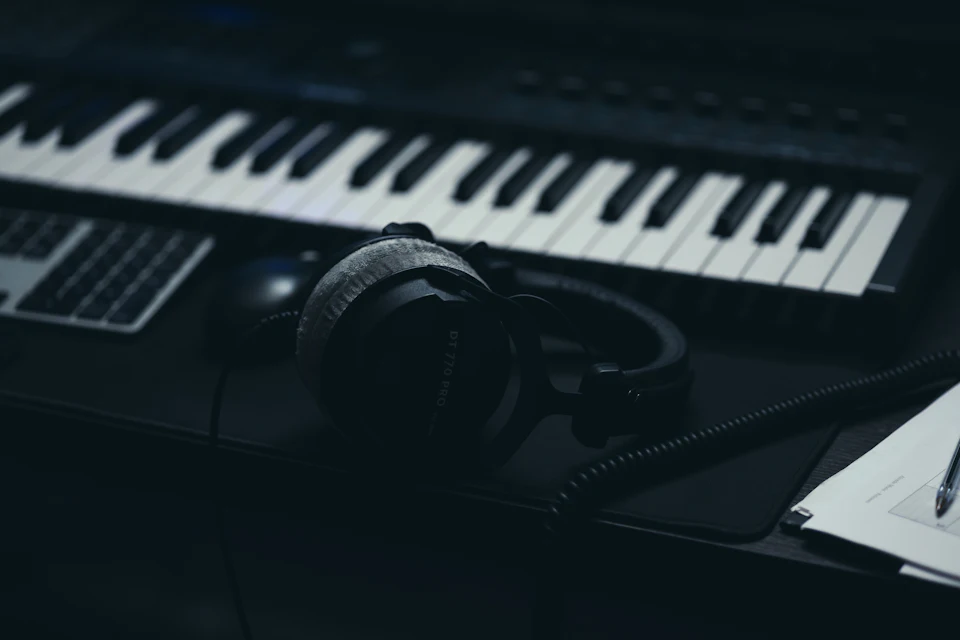 Teclado con auriculares y micrófono en un estudio casero