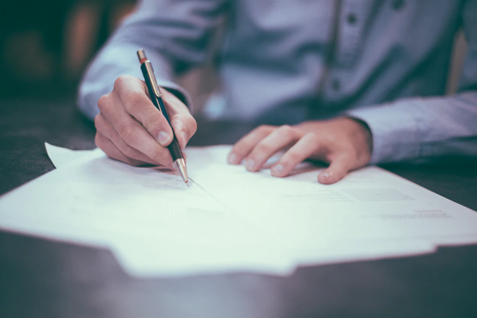Persona escribiendo sobre un documento
