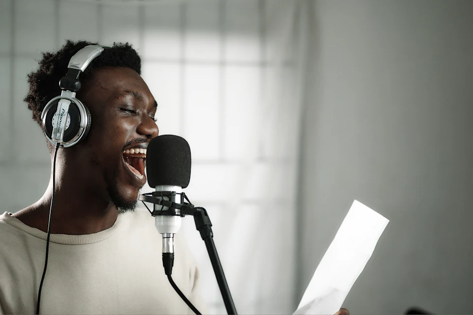 Cantante con auriculares grabando ante un micrófono